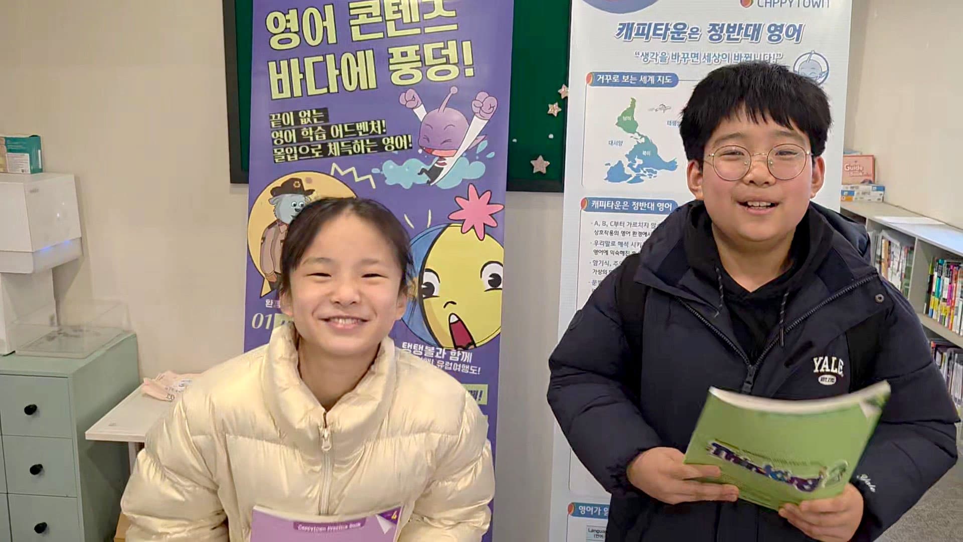 캐피타운 배너 앞에서 밝게 웃는 학생들